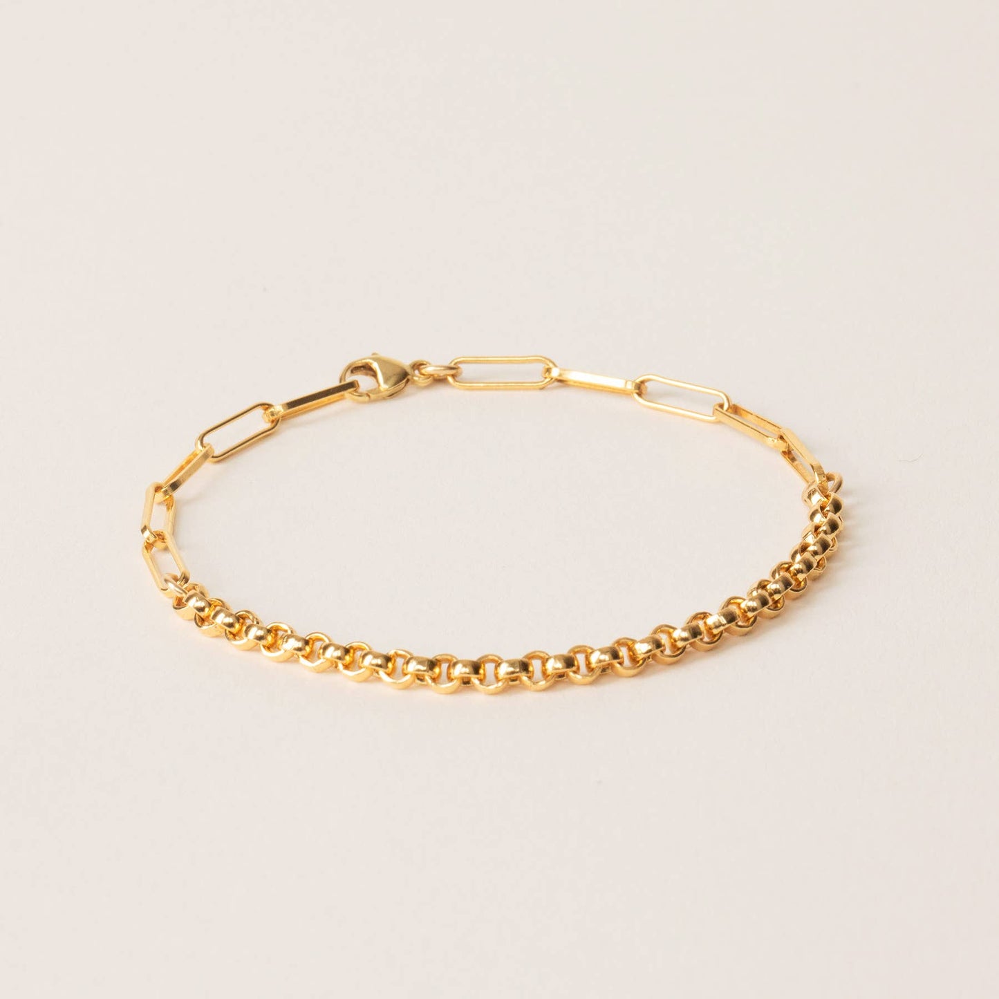 gold chain bracelet with half paperclip half rolo chain on a white background