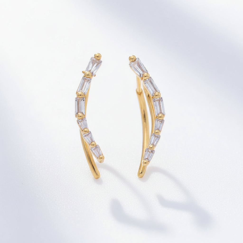 Gold and silver earrings on a light gray background