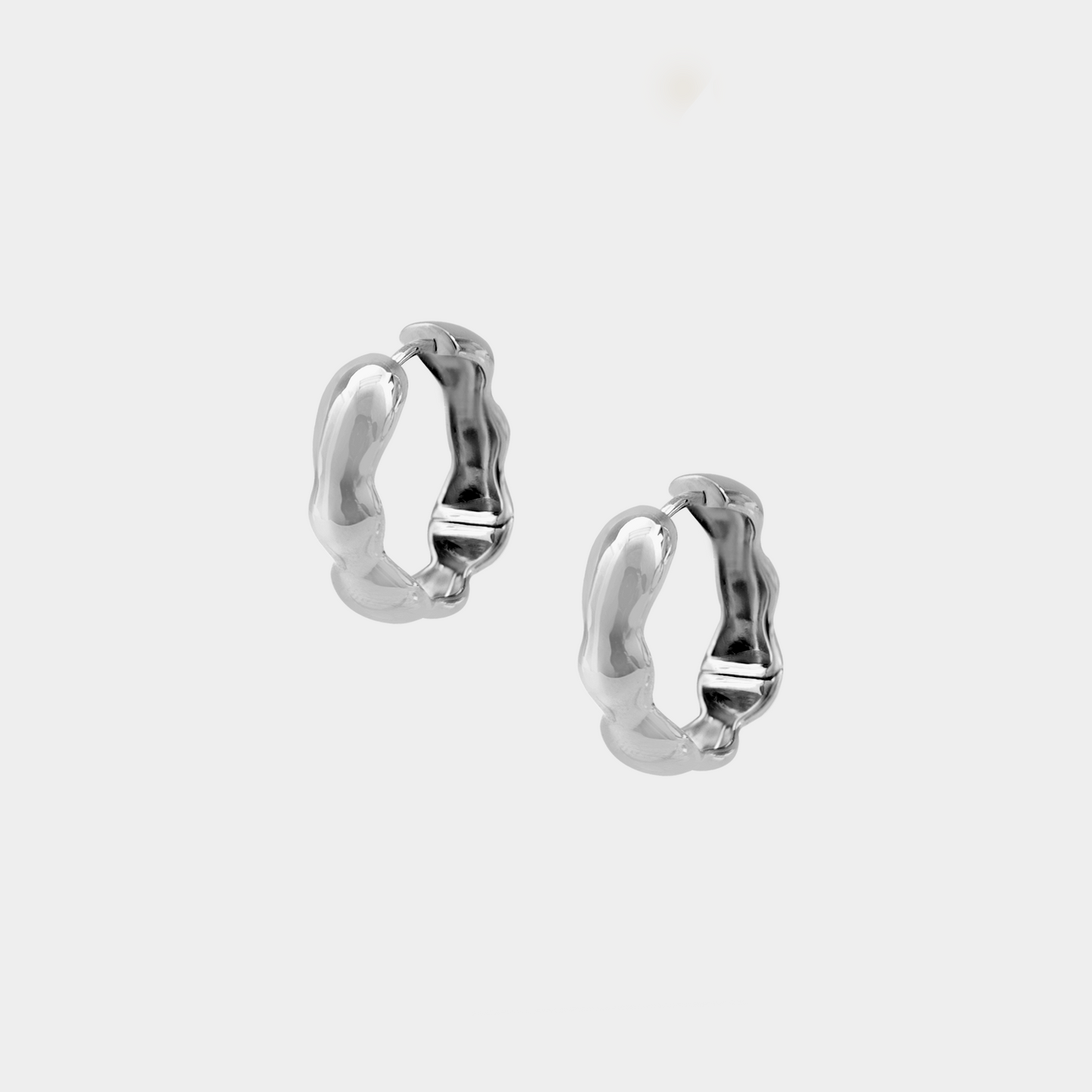 Pair of silver hoop earrings on a white background