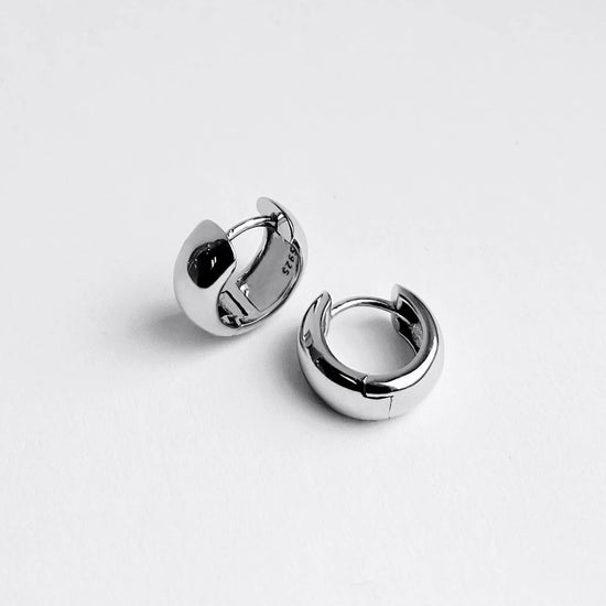 Pair of silver hoop earrings on a white background