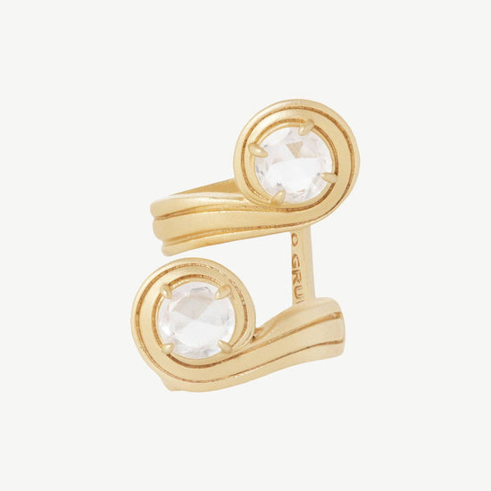 Gold ring with two circular gemstones on a white background