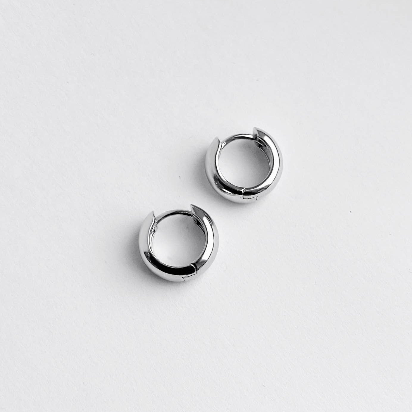 Pair of silver hoop earrings on a white background