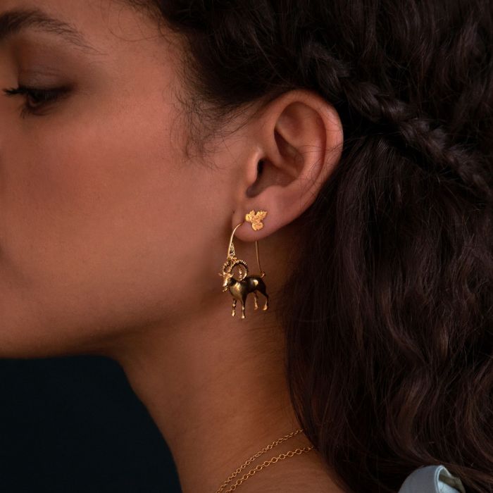 close up of a model wearing the vine leaf stud in her second ear piercing with a gold hoop in the first