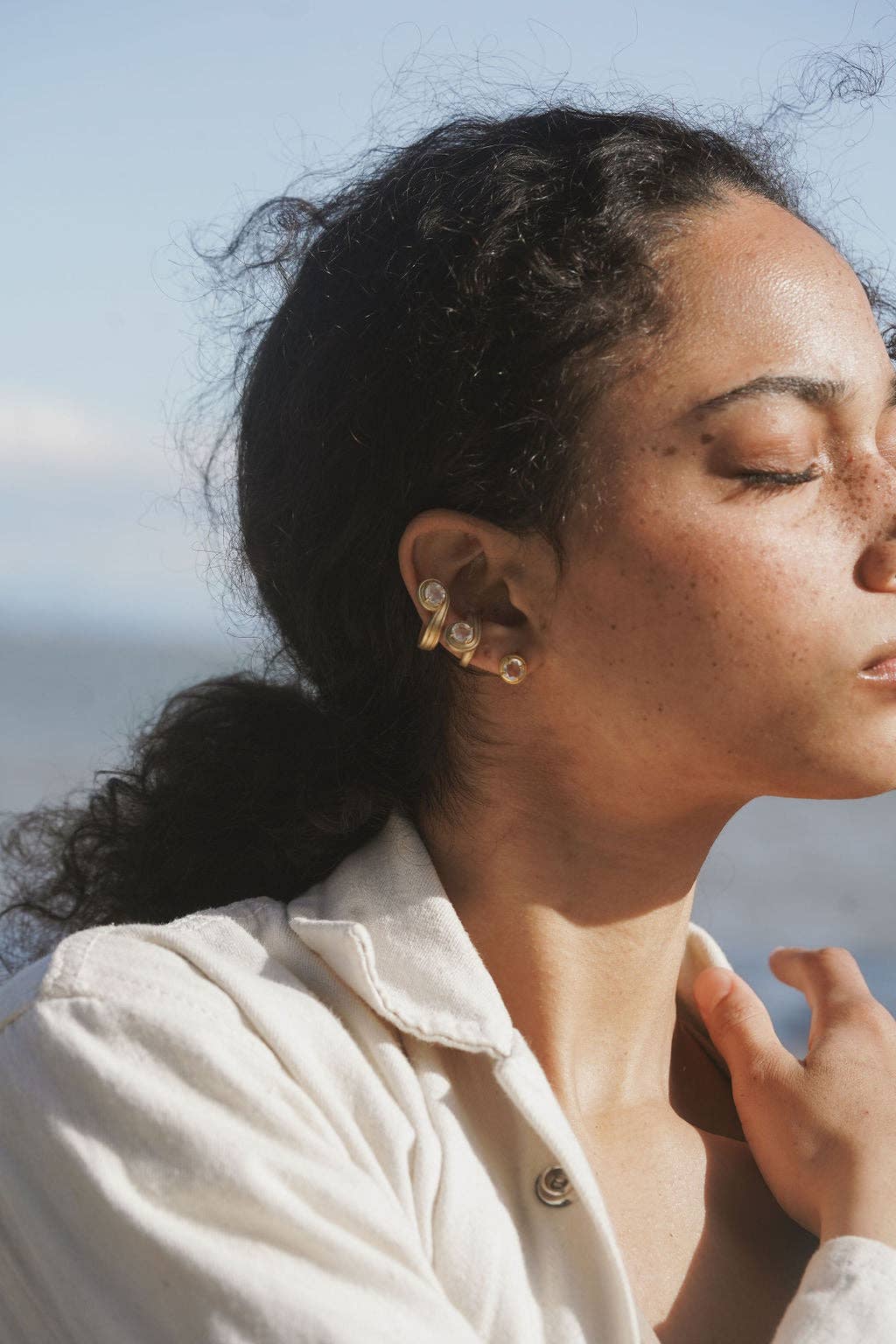 Woman wearing earrings with a blurred natural background