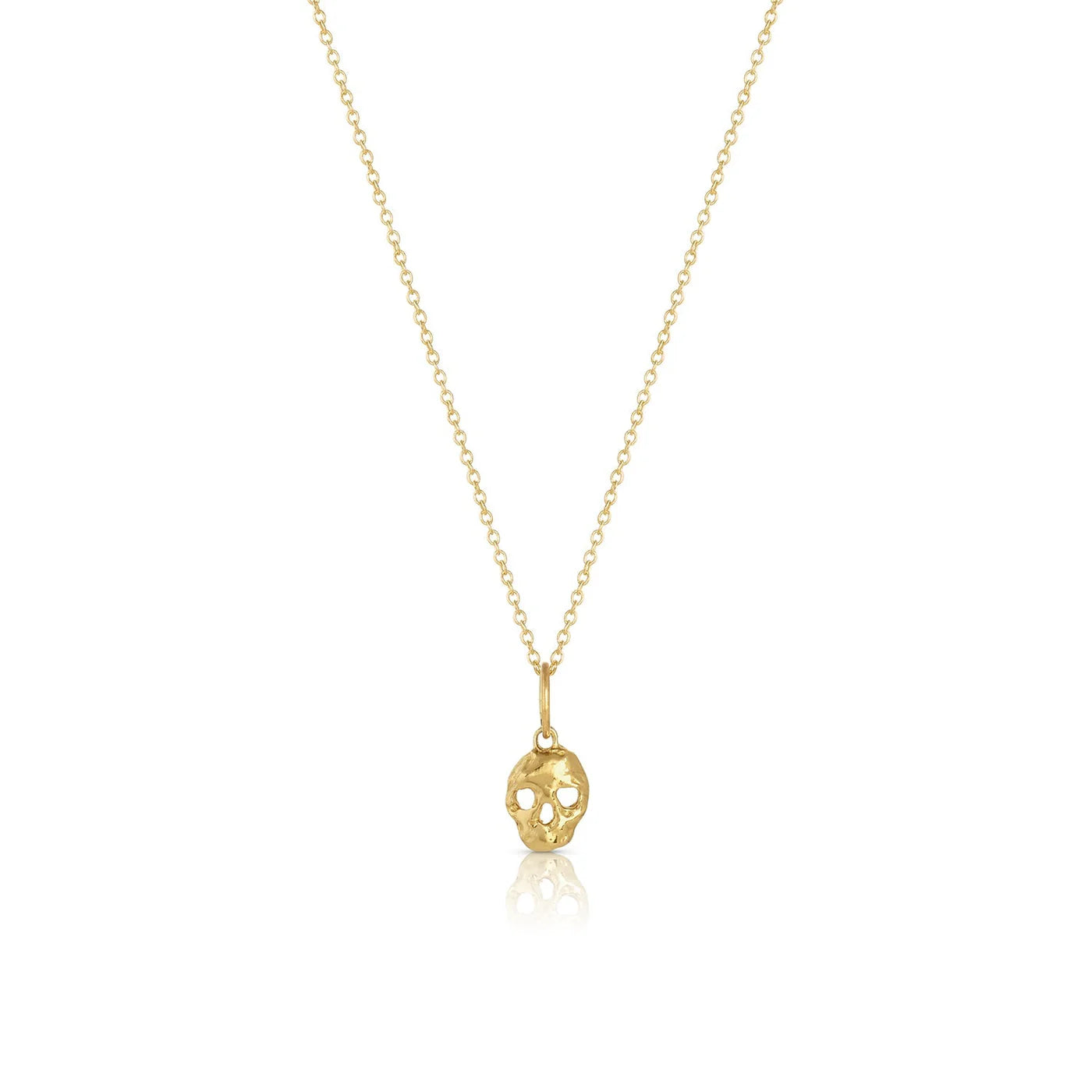 memento mori charm on a thin gold chain on white background