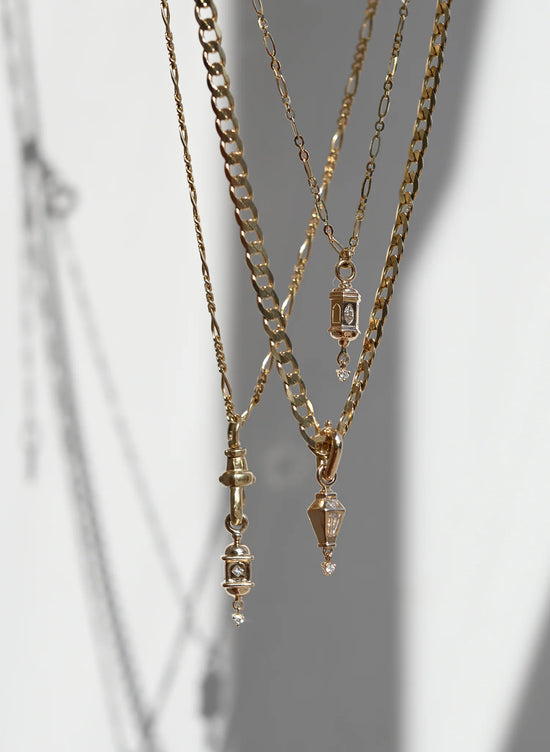 Load image into Gallery viewer, three lantern shaped gold and diamond pendant necklaces dangle on a grey background
