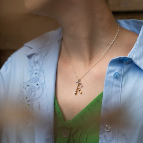 close up of a model wearing the jewelers saw and hammer necklace