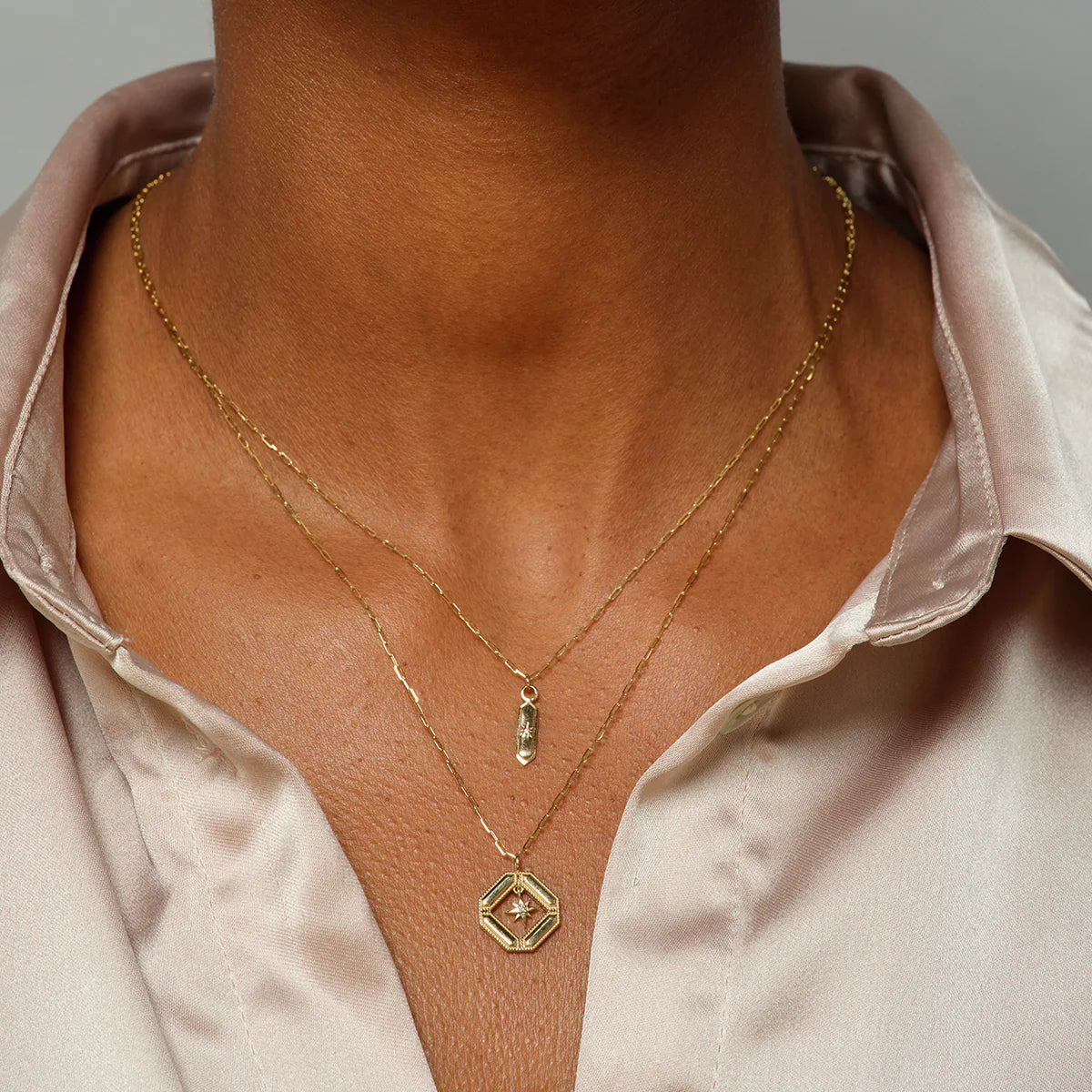 close up of a model wearing the hexa diamond pendant layered with another pendant necklace