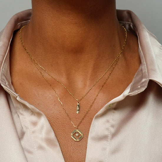 close up of a model wearing the hexa diamond pendant layered with another pendant necklace