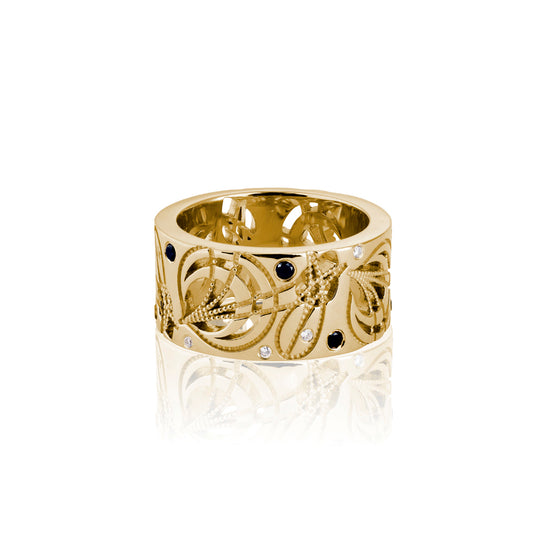 yellow gold cigar band with black and white diamonds on a white photo background 