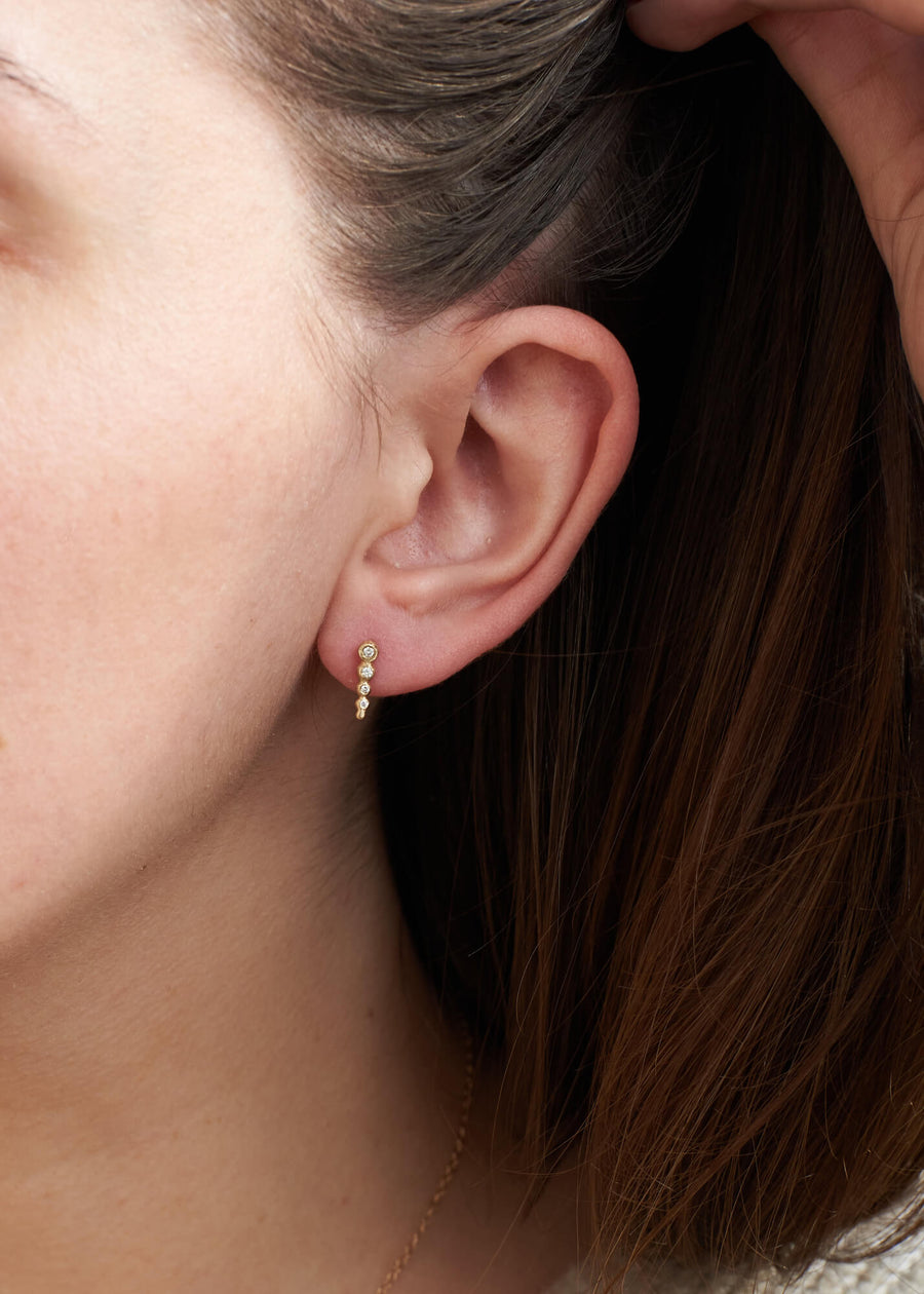 Load image into Gallery viewer, Four diamond droplet stud earring pictured on a womans left ear
