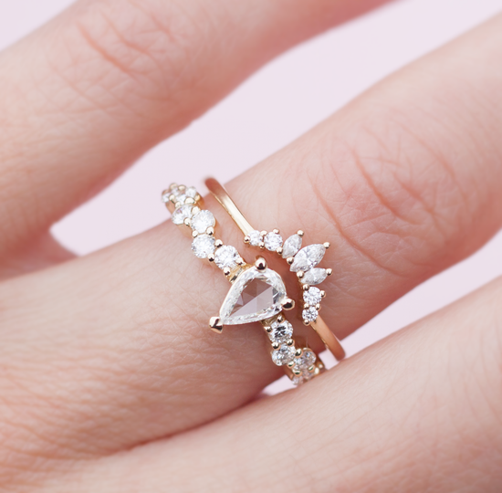 Load image into Gallery viewer, White diamond intertwine ring stacked with a diamond crown band, close up modeled on hand.
