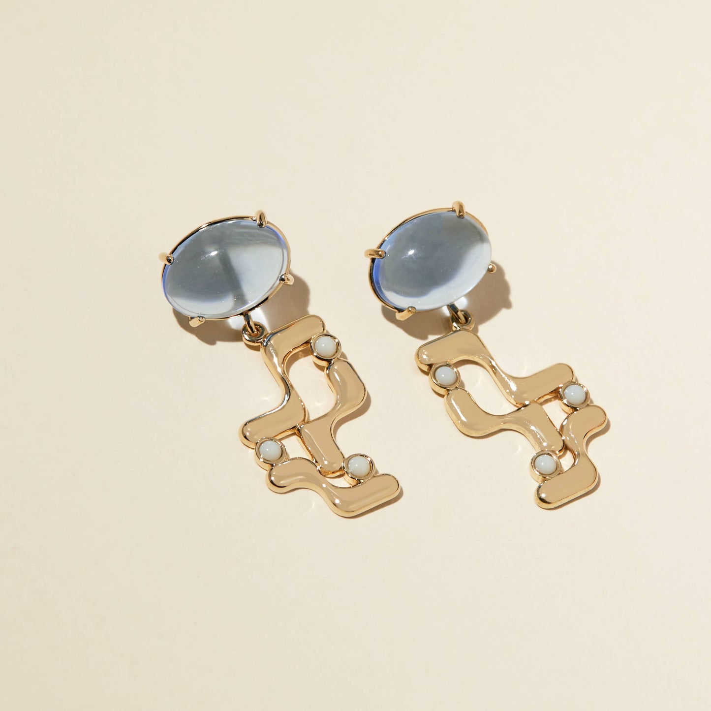 the halsted earrings  angled on a beige background