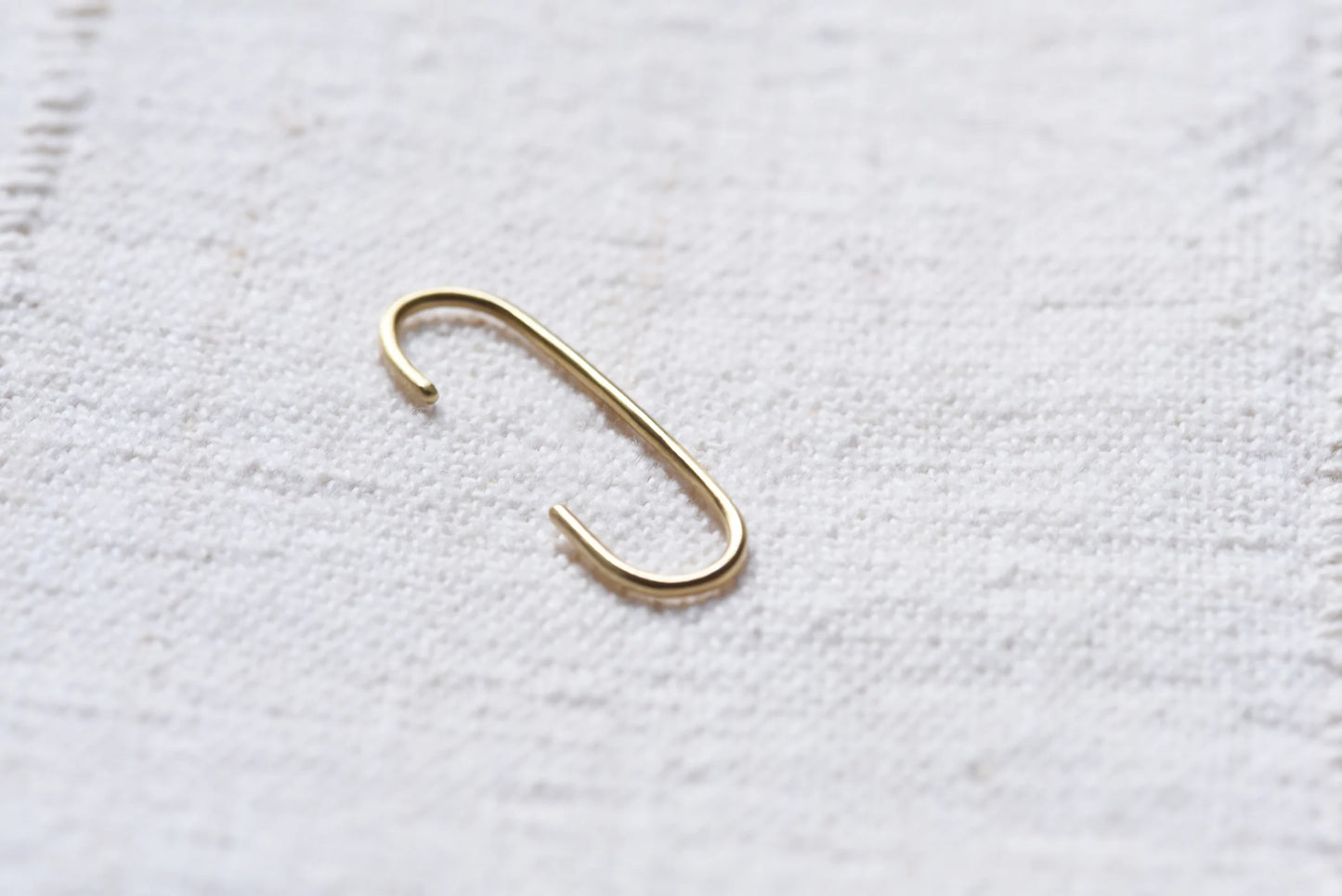 the linea cuff earring on light taupe linen background