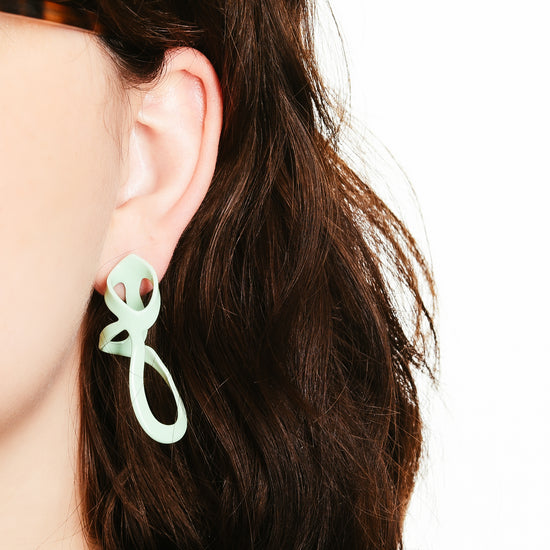 Mint sculptural woven drip earrings, on model.