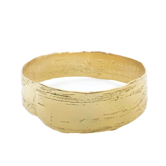 wide gold plated brass bangle on white background