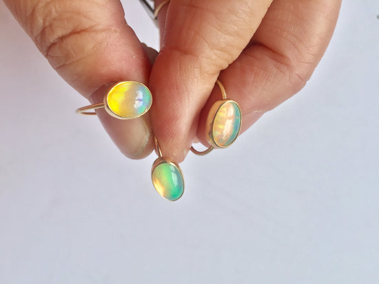 Hand holding 3 opal rings 
