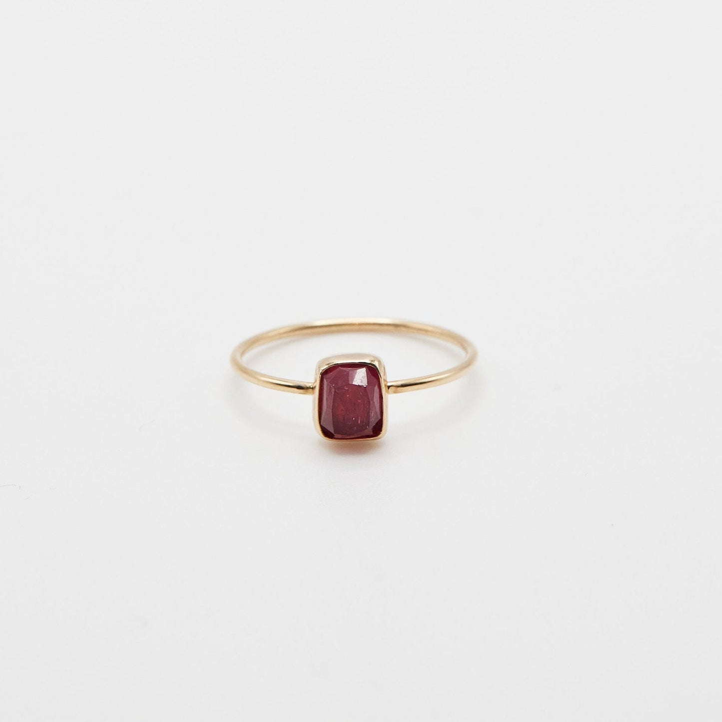 small pink rectangle tourmaline bezel set in 14k yellow gold ring on white background