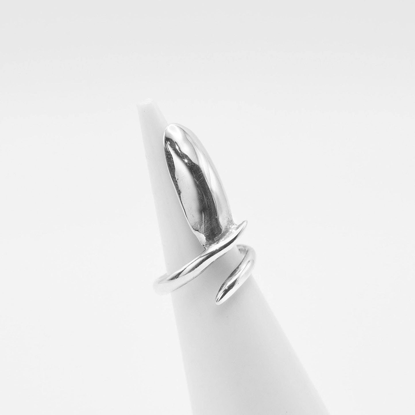 side view of the sleek silver nail ring on white background