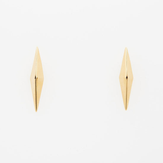 elongated pyramid shaped gold stud earrings on white background