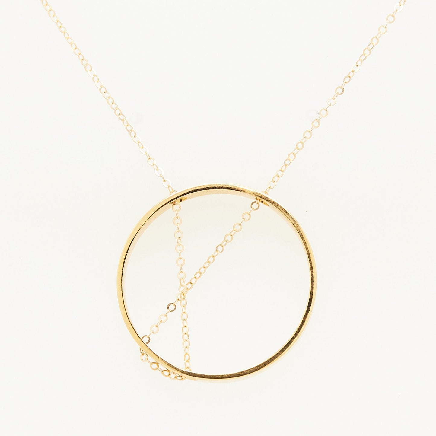 Load image into Gallery viewer, gold open circle pendant with gold chain threaded through on white background
