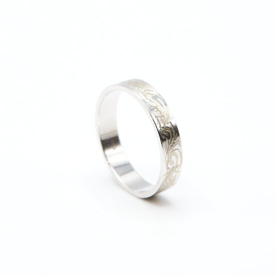 Load image into Gallery viewer, side view of the white gold 4mm band with hand engraving
