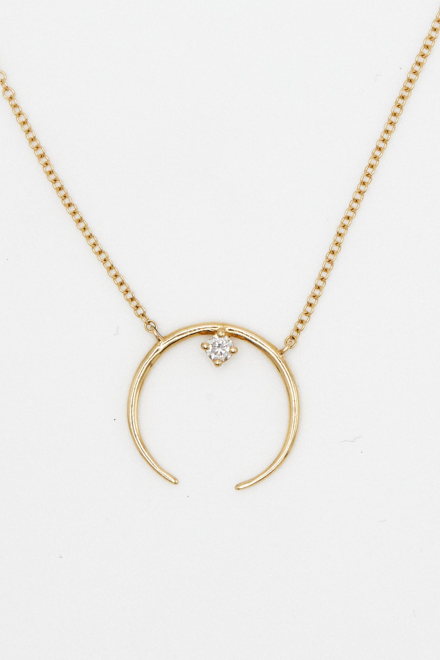 yellow gold open circle pendant necklace with white diamond accent on white background