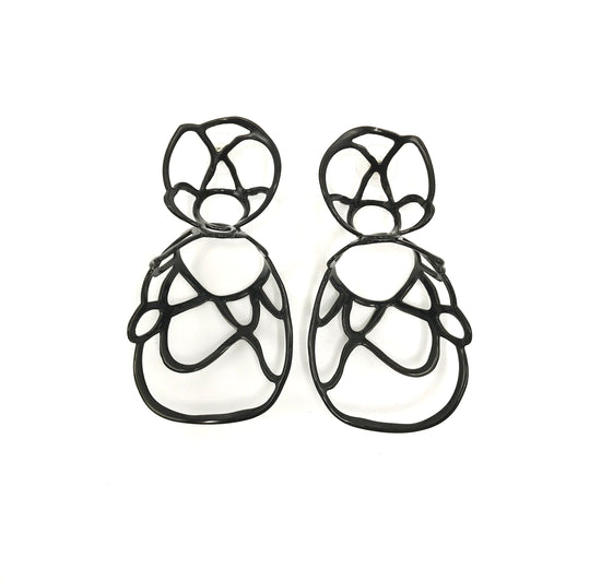Black sculptural double lace statement earrings on white background.