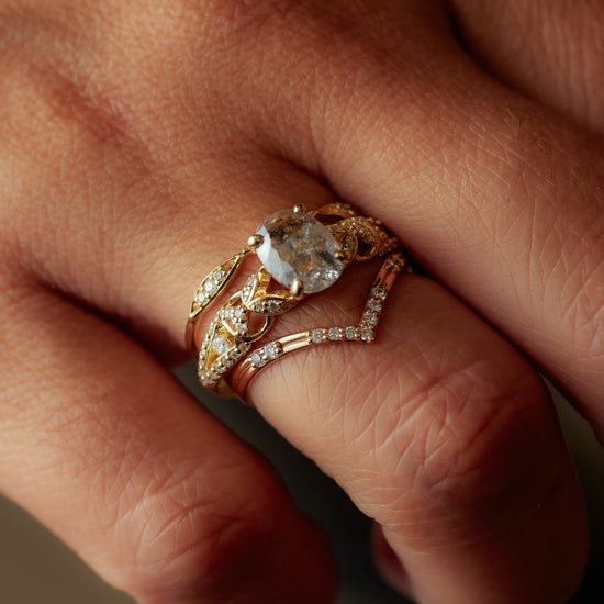Hand wearing the Viviana Ring in yellow gold with a salt and pepper diamond stacked with two diamond bands.
