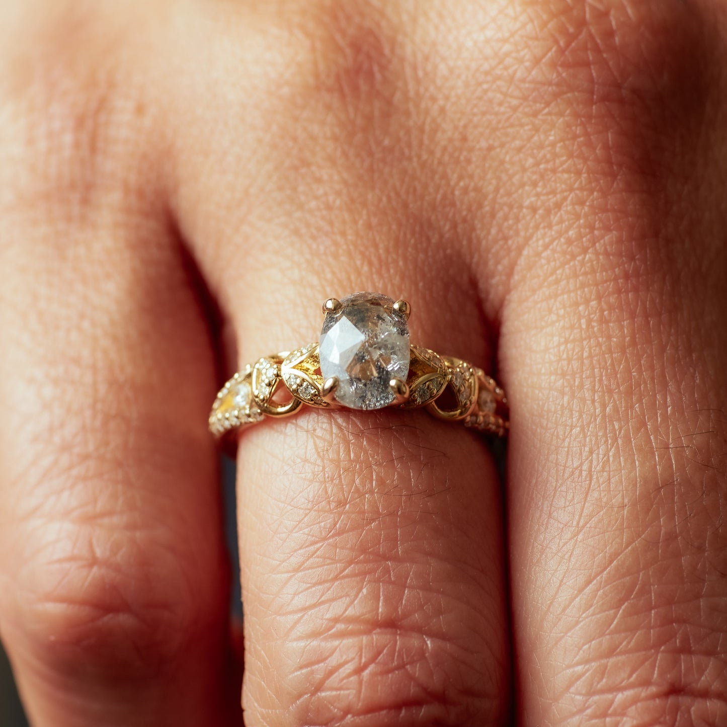 Hand wearing the Viviana Ring in yellow gold with a salt and pepper diamond.