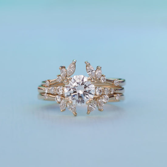 Load image into Gallery viewer, Diamond solitaire Rheia ring stacked with two white diamond bands on light blue background.
