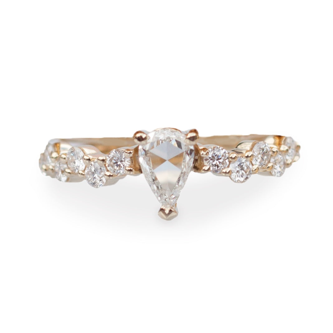 Rose cut pear shaped diamond ring with diamond cluster band, close up on white background.