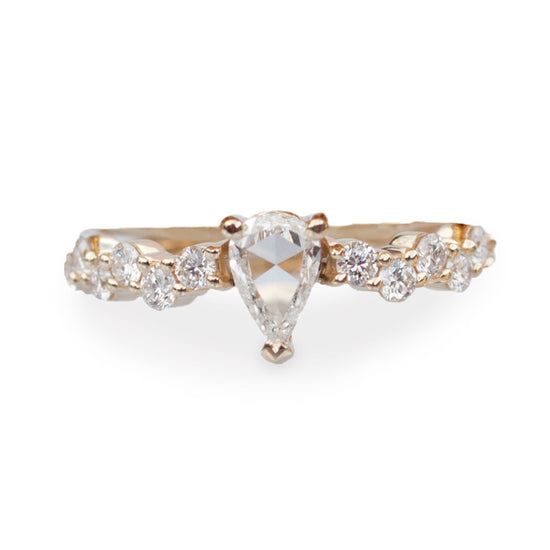 Rose cut pear shaped diamond ring with diamond cluster band, close up on white background.