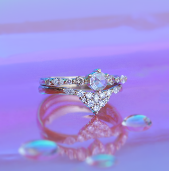 Diamond solitaire spirit dust ring stacked with a diamond band on multi color background.