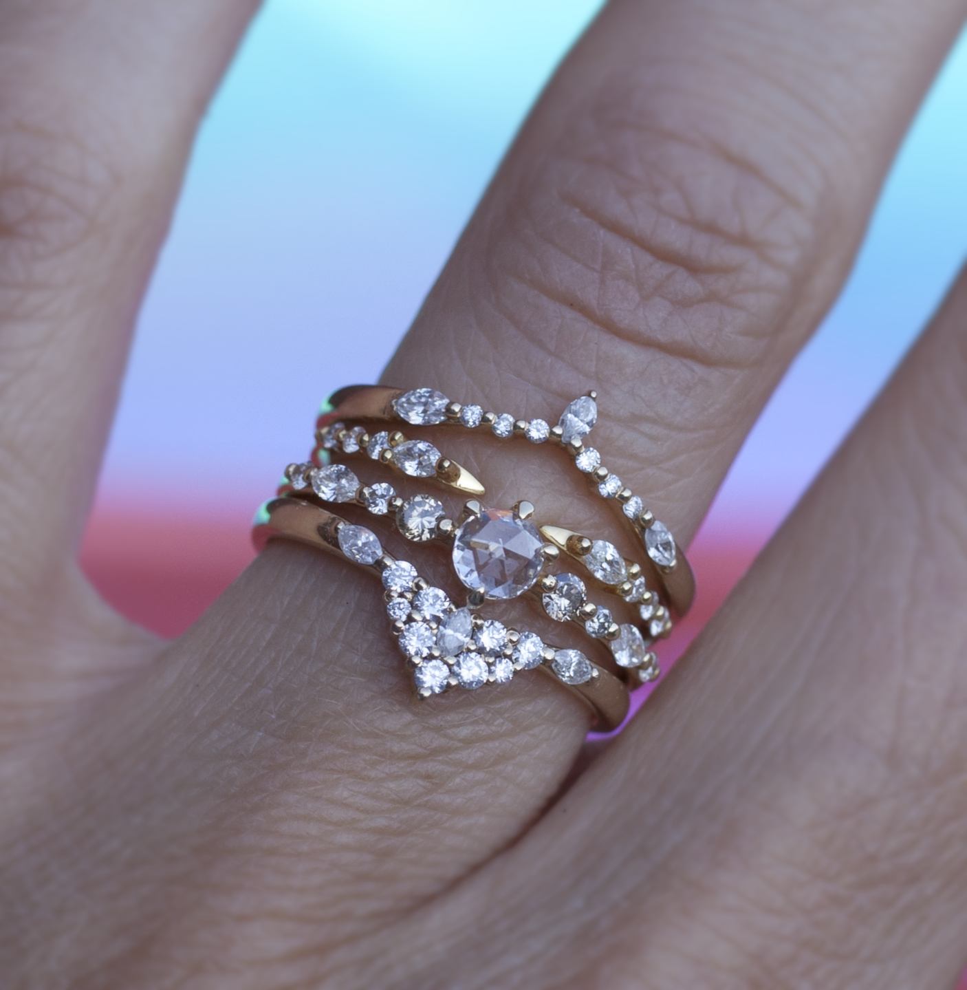 Diamond solitaire spirit dust ring stacked with three diamond bands modeled on hand.