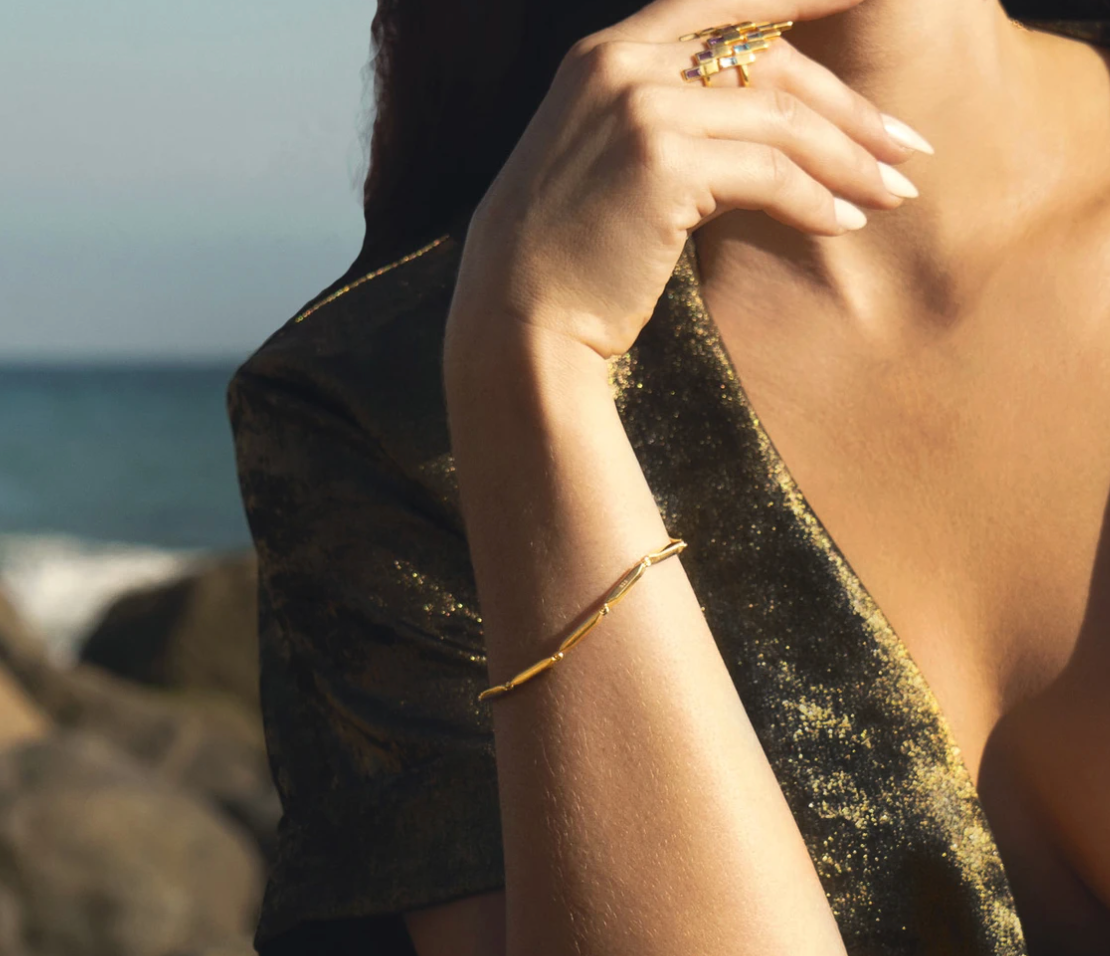 Model wearing the gold link Sol bracelet.