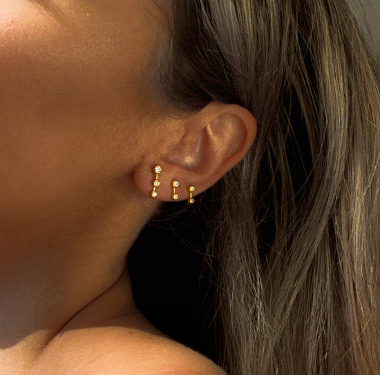 Load image into Gallery viewer, model wearing three star dust earrings.
