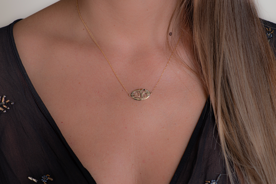 Close up of model wearing a yellow gold pendant