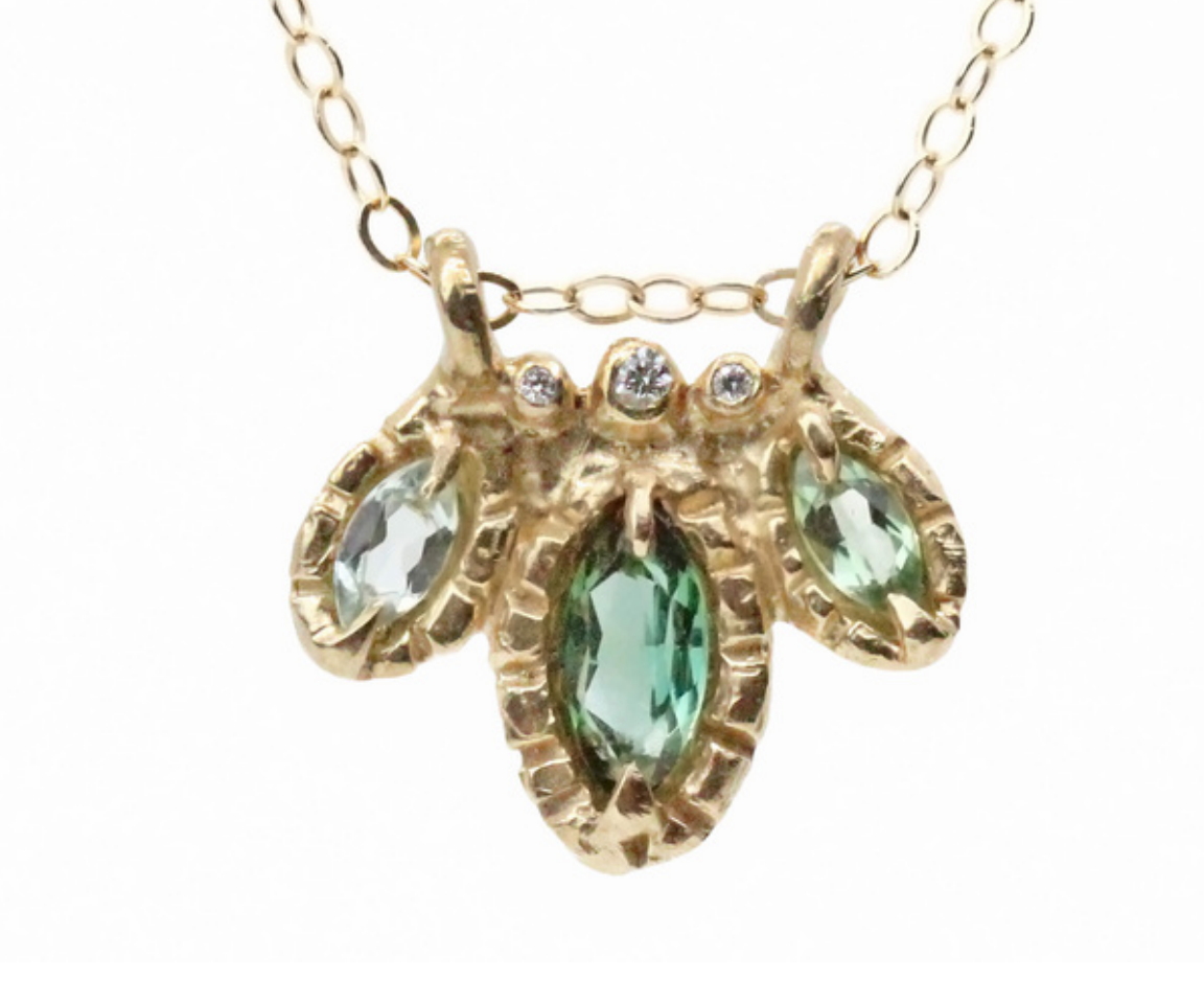 3 green marquis cut garnets, accompanied by diamonds, on gold chain pictured on white background