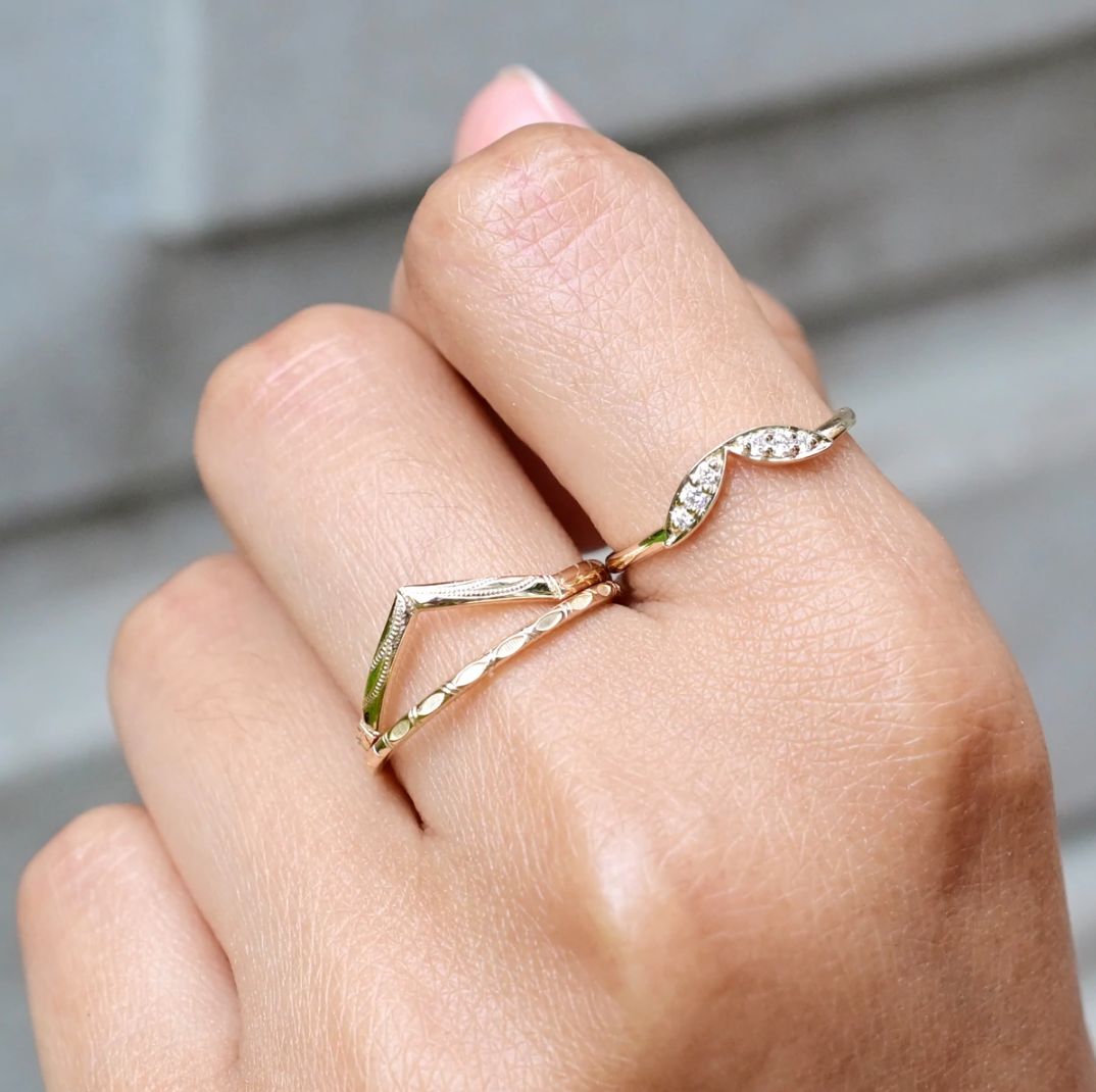 model wearing the gold engraved v band with two other gold bands 