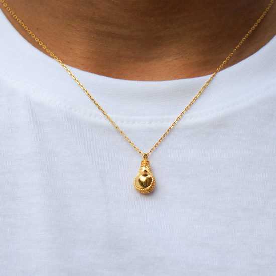 model wearing the lightbulb shaped gold pendant necklace