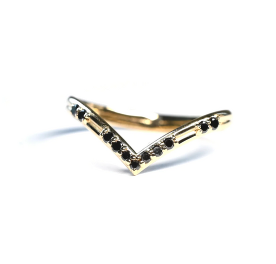 yellow gold v shaped band with scattered black diamonds on white background