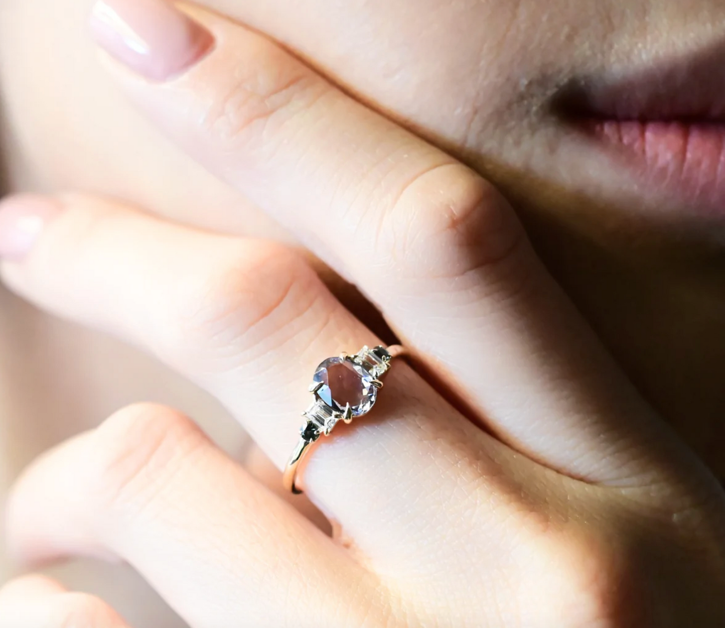 close up of a model wearing the spinel lilac oval ring on her middle finger with her hand resting on her face