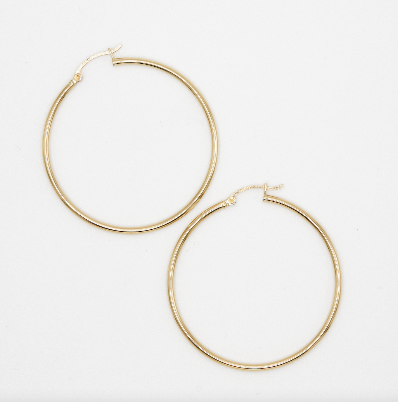 classic yellow gold hoop earrings on white background
