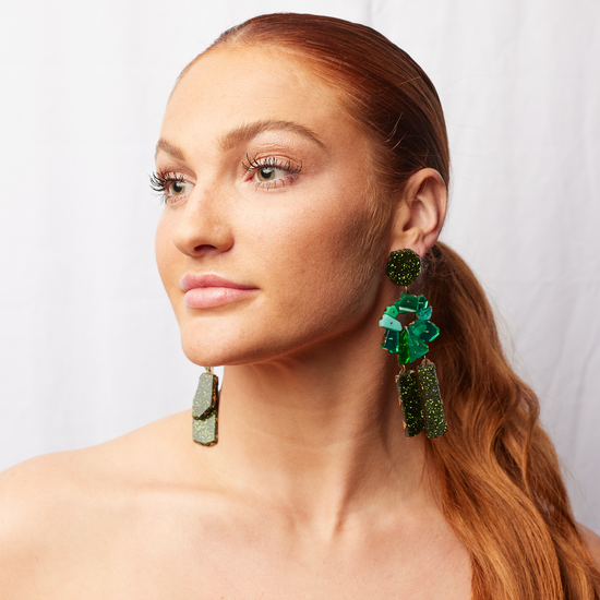 model wearing the emerald drop earrings, with a white background