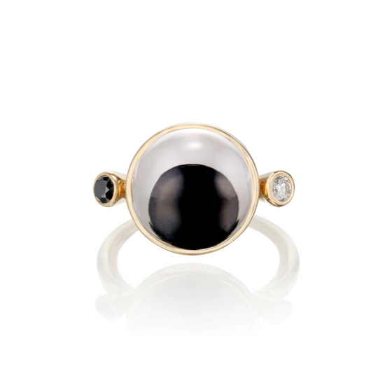 a gold ring with a black and white googly eye with a black and white diamond accent on each side. On a white background