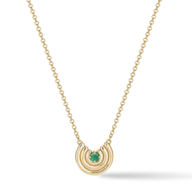 gold semi circle pendant with a round emerald center stone and a gold chain on white background