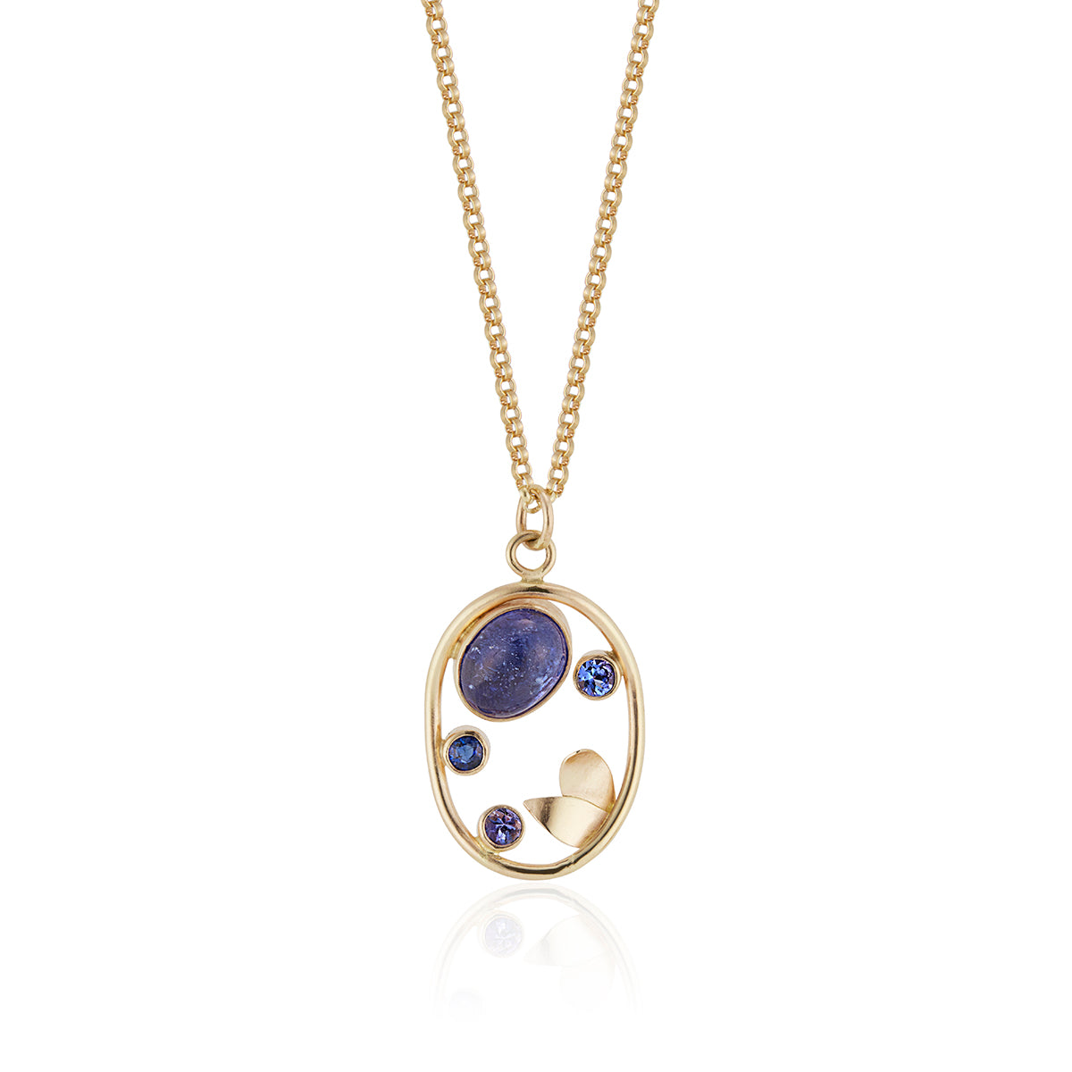 Tanzanite and sapphire stones set on a yellow gold pendant, photographed on a white background