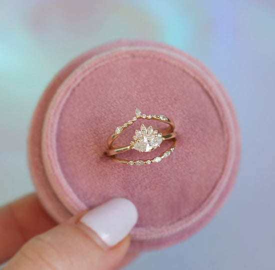 White diamond sideways set marquise gold ring with diamond crown, in a pink ring box with the diamond bands.