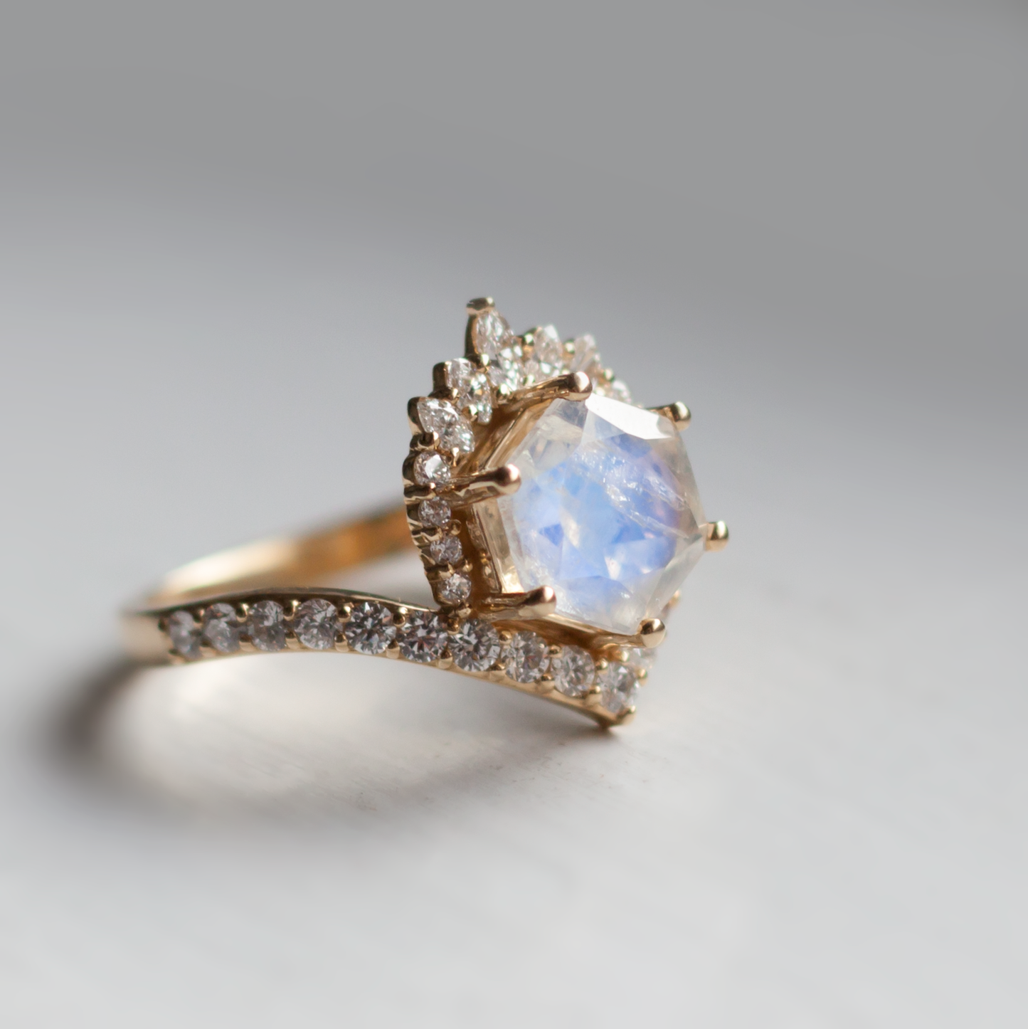 Side view of the moonstone devoir ring on a grey background.